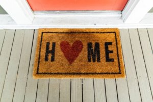A door welcome mat with the word home on it for a lifestyle trend article about delivery and subscription-based products and services