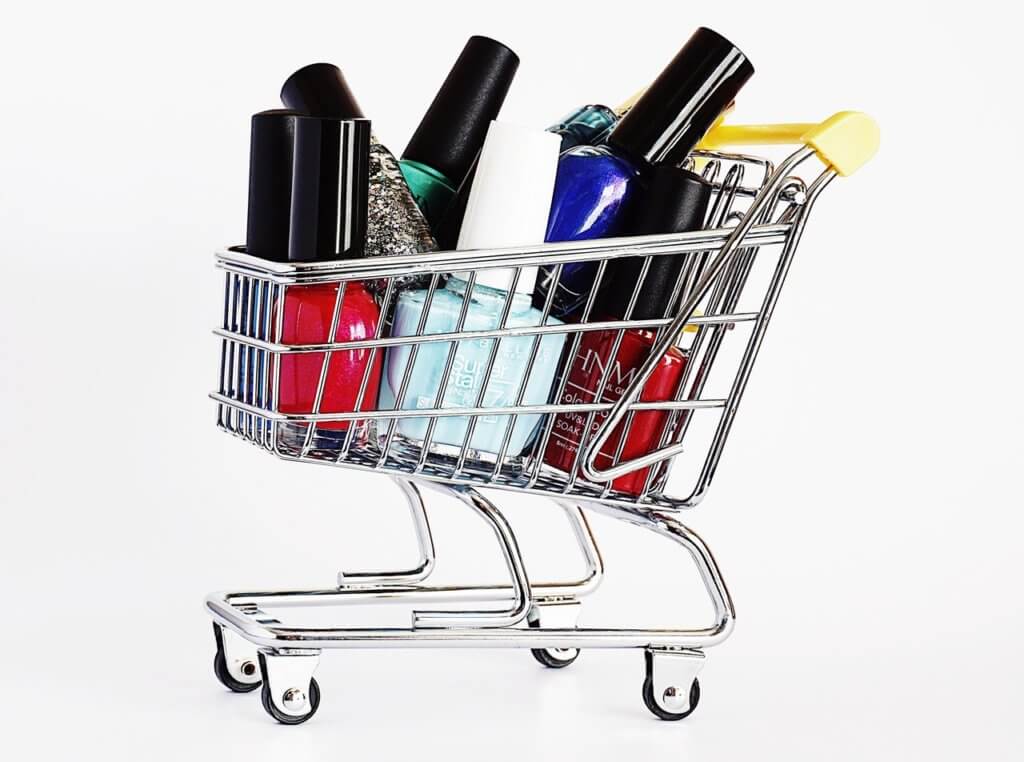 A shopping cart filled with a variety of colored nail polish for an article about new nail care applications and technology