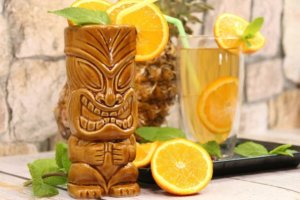 A close up of a Tiki cocktail with orange slices and mint for a lifestyle trend article on Tiki themed products and services