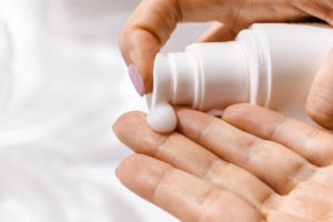 A close up of a woman applying hand cream for an ingredient article about collagen infused food, beverage and beauty products