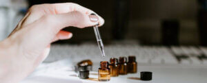 Woman's hand dropping fragrance into small brown bottles
