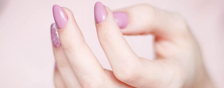 Woman's hand up with pink gel nail polish