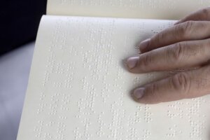Hand reading braille to depict inclusive consumer goods packaging design