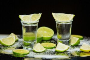 Two shots of tequila with limes and salt scattered