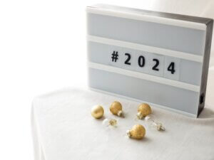A look back at 2023 trends with a #2024 sign and gold ornaments