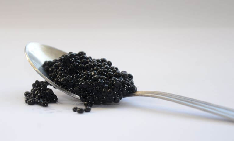 Black caviar on silver spoon for a trend article about caviar as a hot ingredient
