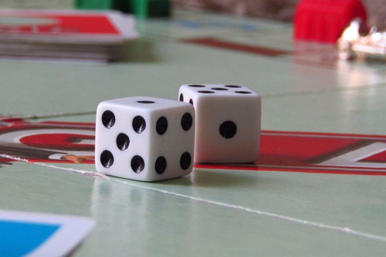 Close up dice on Monopoly board for a trend article about food, beverage and beauty brands launching games and toys